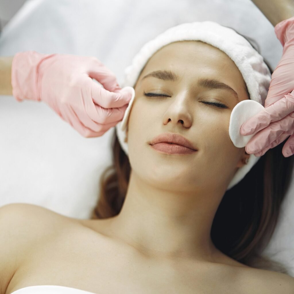 Woman enjoying a soothing facial treatment in a serene spa setting, promoting relaxation and beauty.